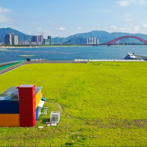 green field with city and bay in background