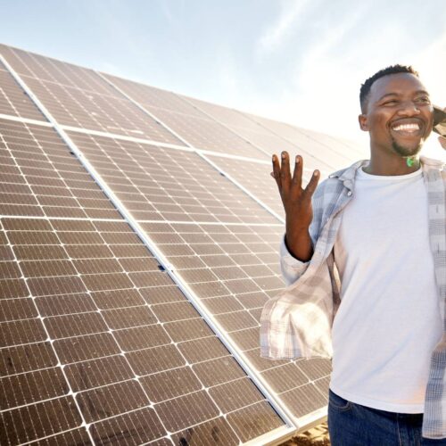 man on phone in front of solar panel