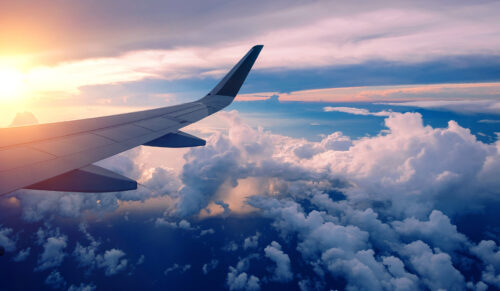 plane wingtip in flight over clouds